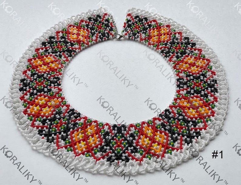 May include: A beaded necklace with a white scalloped edge. The necklace features a repeating pattern of red, orange, yellow, and black beads. The text "KORALIKY" and the number "1" are visible.