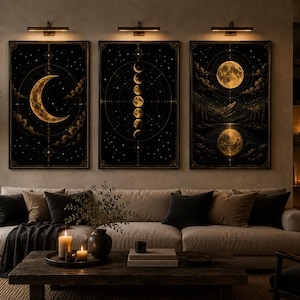 Könnte beinhalten: Ein Set aus drei rechteckigen Wandbildern mit goldenen Mondphasen, Sternen und Berglandschaften auf schwarzem Hintergrund, gerahmt in schmalen schwarzen Rahmen mit jeweils einer eigenen Wandleuchte über jedem einzelnen Bild.