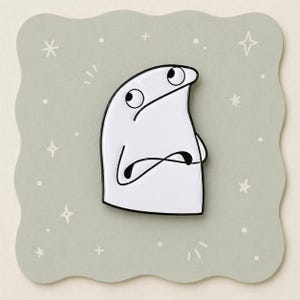 May include: A white enamel pin featuring a cartoon character with a skeptical expression, arms crossed. The pin has a black outline and is set against a light green, scalloped-edge background with star and dot accents.