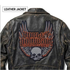 May include: Distressed black leather jacket featuring a Harley-Davidson Motorcycles patch on the back. The patch includes a skull, wings, and the brand name in orange and gray.