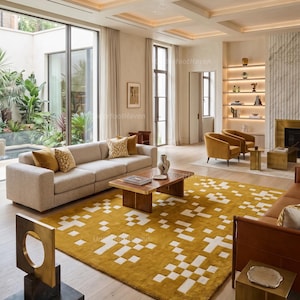 May include: A large rectangular area rug featuring a mustard yellow background with a repeating white geometric pixelated pattern. The rug is positioned in a living room with a beige sofa, two mustard yellow armchairs, and a wooden coffee table.