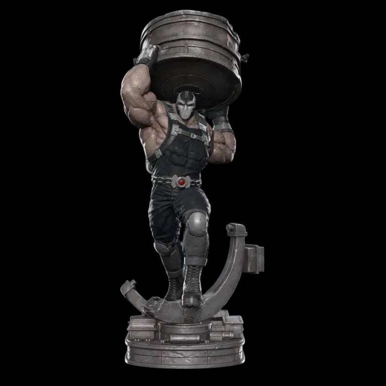 May include: A detailed statue of a muscular figure in a black outfit, wearing a mask, and lifting a large metal cylinder overhead. The figure stands on a circular base with a stylized support. The statue has a dark color palette.