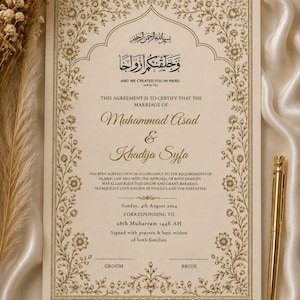 May include: A cream-colored marriage certificate featuring gold floral borders and Arabic calligraphy. The text reads: And we created you in pairs, Muhammad Asad and Khadija Syfa, Sunday, 4th August 2024, 28th Muharram 1446 AH. A gold pen is placed on the right side.