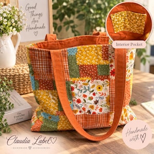 May include: A patchwork tote bag featuring a variety of autumn-themed fabric squares in shades of orange, yellow, green, and white. The bag has two long orange fabric straps and an interior pocket with a yellow floral print pattern.