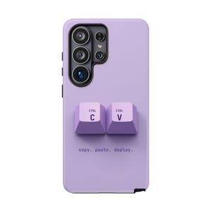 May include: A light purple smartphone case featuring two raised keyboard keys labeled CTRL C and CTRL V. Below the keys, the text copy. paste. deploy. is printed in a dark purple font. The case has a black camera module cutout at the top.