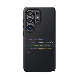 May include: A matte black smartphone case featuring a multi-coloured code snippet printed on the back. The text reads: function life() { const coffee = brew(); // TODO: fix later return ship(coffee); }. The case has a cutout for a multi-lens camera.
