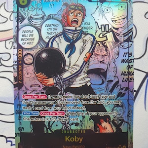 May include: A holographic trading card featuring the character Koby from the Navy/Sword series. The card has a colorful manga-style illustration of Koby holding a chained ball. Text includes "Koby", "Navy/Sword", and game instructions.