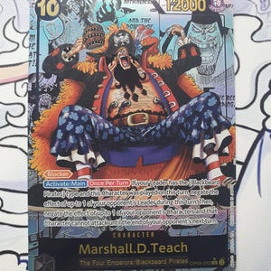 Puede incluir: Carta coleccionable con Marshall D. Teach de los Cuatro Emperadores/Piratas de Barbanegra. La carta presenta una colorida ilustración del personaje, con el número 10 en la esquina superior izquierda y 12000 en la superior derecha. El texto describe las habilidades del personaje.