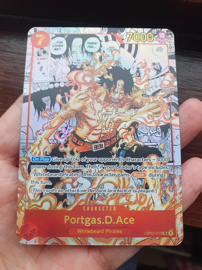 May include: A trading card featuring the character Portgas D. Ace from the "Whitebeard Pirates" series. The card has a red and orange color scheme with the number 7 in the top left corner and the text "7000" in the top right. The card includes text and illustrations.