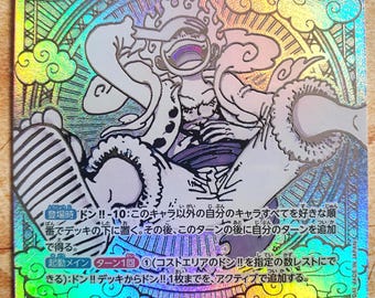 May include: Holographic trading card featuring Monkey D. Luffy from One Piece. The card has a colorful, iridescent background with Japanese text and character details. The character is depicted in a dynamic pose, with a value of 10 and 12,000.