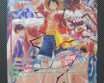 Puede incluir: Una carta coleccionable de One Piece con Monkey D. Luffy en varias formas, incluyendo Gear 5. La carta muestra un coste de 10, 11000 de poder y texto sobre las habilidades Rush y Blocker. El personaje viste un chaleco rojo, pantalones cortos y sombrero.