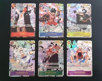 Puede incluir: Seis cartas coleccionables rectangulares de One Piece dispuestas en dos filas. Las tarjetas presentan coloridas ilustraciones estilo manga de personajes como Shanks, Monkey D. Luffy, Trafalgar Law y Roronoa Zoro, con texto impreso y niveles de poder.