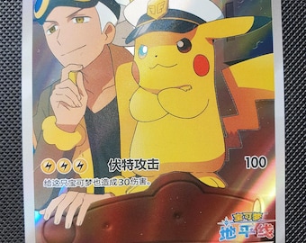 Puede incluir: Una carta coleccionable holográfica que muestra a un personaje de pelo blanco con gafas junto a un Pikachu amarillo con gorra de capitán. La carta muestra el texto 船长皮卡丘, 70 HP y 伏特攻击 100. La ilustración incluye un elemento de timón marrón en la parte inferior.