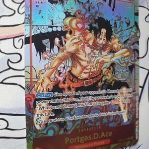 May include: A holographic trading card featuring the character Portgas D. Ace from the "Whitebeard Pirates" series. The card has a vibrant design with a fiery theme, a character illustration, and game text. The card has a 7000 power level.