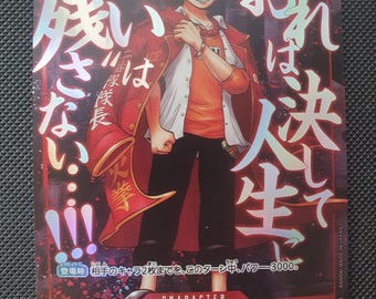 Puede incluir: Una tarjeta coleccionable rectangular que muestra un personaje de anime con cabello oscuro, vistiendo una camisa naranja, una chaqueta blanca abierta y un abrigo rojo. La tarjeta tiene un fondo rojo oscuro con texto japonés blanco y el nombre Portgas D. Ace.