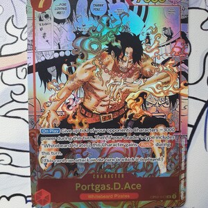 May include: A holographic trading card featuring the character Portgas D. Ace from the "Whitebeard Pirates" series. The card has a red and gold color scheme, with the number 7 in the upper left corner and the character's name at the bottom.