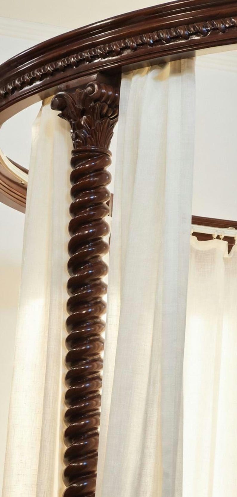 Detail of hand-carved spiral wooden pillars on a solid teak four-poster canopy bed inspired by classic Italian furniture.