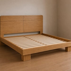 May include: A light brown wooden bed frame featuring a tall, rectangular headboard with a central vertical seam and a horizontal line detail. The base consists of a sturdy wooden perimeter frame supported by four block legs and light-colored slats.