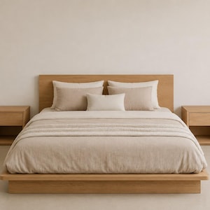 May include: A light oak platform bed frame with a matching headboard, featuring a beige duvet cover, two large beige pillows, two smaller beige pillows, and one central rectangular beige pillow, flanked by two matching light oak nightstands.