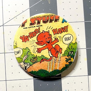 May include: A round button featuring a vintage comic book illustration. The image shows a red devil character with horns, jumping and laughing, with the words "Ya-Hoo! Haw! Eek!" in speech bubbles. The background is yellow.