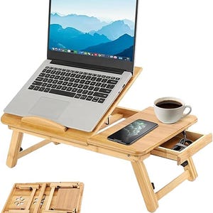 May include: A bamboo laptop desk with an adjustable tilting surface, a side tray, and a small storage drawer. The desk holds a silver laptop, a smartphone, and a white ceramic mug. A second view shows the desk folded flat with ventilation holes.