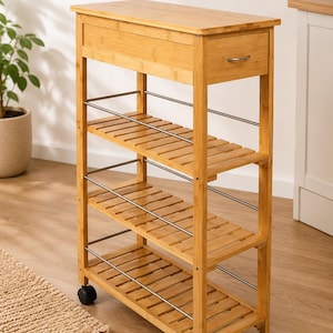 May include: A tall, narrow bamboo storage trolley featuring a flat top surface, one top drawer with a small silver handle, and three slatted shelves. The unit is supported by four black caster wheels and includes thin silver metal side rails.