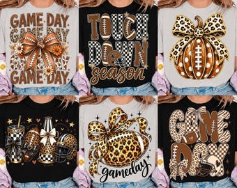 May include: A collection of six t-shirts featuring various graphic designs related to football. The prints include text like GAME DAY, TOUCH DOWN SEASON, and gameday, alongside illustrations of footballs, helmets, bows, and pumpkins with leopard patterns.