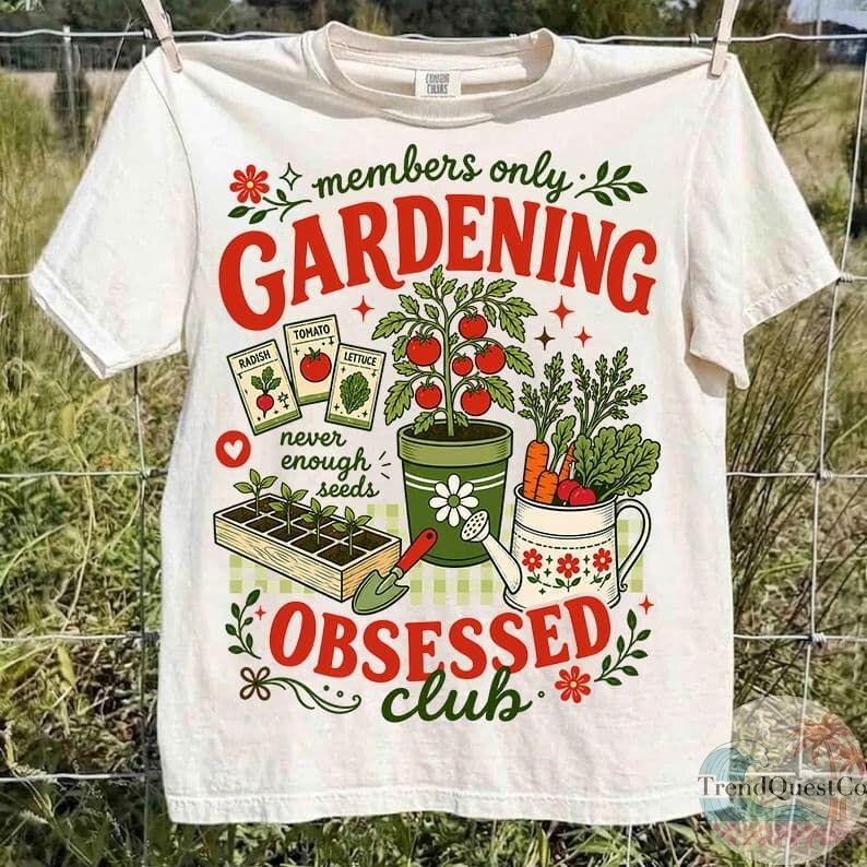 Puede incluir: Camiseta blanca con tem&aacute;tica de jardiner&iacute;a. La camiseta presenta el texto "members only GARDENING OBSESSED club" en rojo y verde, junto con ilustraciones de sobres de semillas, una planta de tomate, zanahorias y una regadera.
