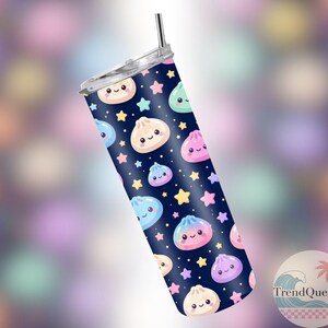 May include: A navy blue tumbler with a silver lid and straw. The tumbler features a pattern of smiling dumplings and stars in various colours. The tumbler is cylindrical in shape.