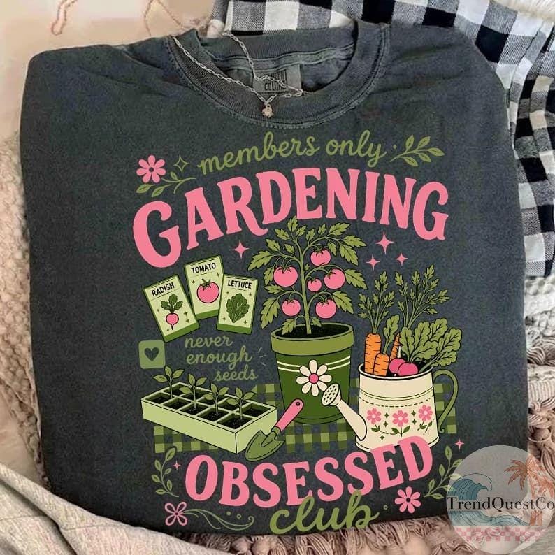 Puede incluir: Sudadera gris oscuro con un dise&ntilde;o de jardiner&iacute;a rosa y verde. El dise&ntilde;o incluye las palabras "members only GARDENING OBSESSED club", sobres de semillas, una planta de tomate, zanahorias y una regadera.