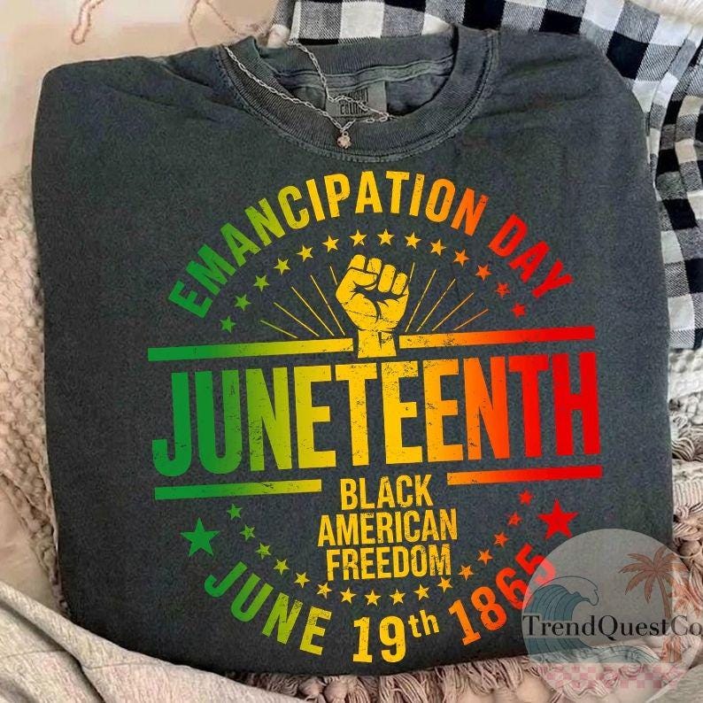 May include: Dark gray crew neck sweatshirt with a colorful Juneteenth graphic. The design includes the words "Emancipation Day" and "Juneteenth" in a vibrant, multi-colored font, along with the text "Black American Freedom" and "June 19th 1865".