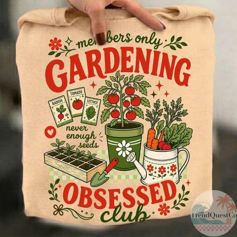 Puede incluir: Sudadera beige con tem&aacute;tica de jardiner&iacute;a. El dise&ntilde;o incluye las palabras "Gardening Obsessed Club" en rojo y verde, junto con ilustraciones de verduras, sobres de semillas y herramientas de jardiner&iacute;a. Tambi&eacute;n se incluye el texto "never enough seeds".