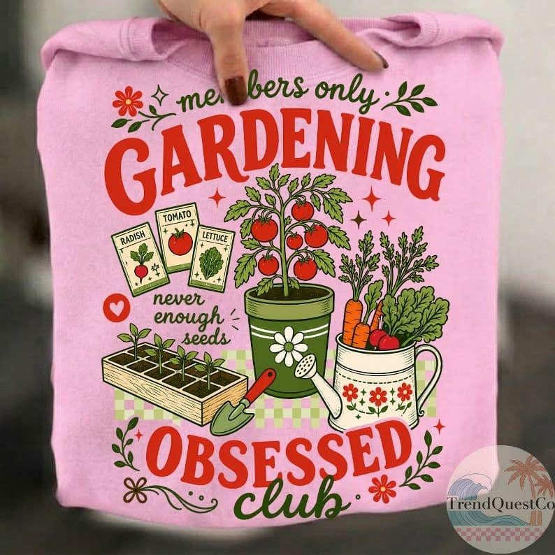 Puede incluir: Sudadera rosa con un dise&ntilde;o de jardiner&iacute;a. El dise&ntilde;o incluye las palabras "members only GARDENING OBSESSED club" en rojo, junto con ilustraciones de verduras, sobres de semillas y herramientas de jardiner&iacute;a. La sudadera es sostenida por una mano.