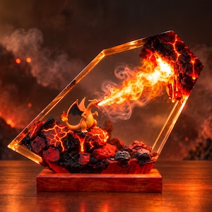 Könnte beinhalten: Ein Harz-Diorama mit einer orangefarbenen, drachenähnlichen Kreatur auf einem dunklen, strukturierten Vulkangesteinssockel mit glühenden roten Lavaadern. Die Kreatur speit eine Flamme in Richtung einer kristallinen Struktur mit glühender Glut.
