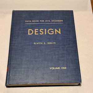 Puede incluir: Un libro de tapa dura azul oscuro titulado Data Book for Civil Engineers, Design, Volume One de Elwyn E. Seelye. La portada presenta letras doradas y un acabado de tela texturizada, con un pequeño acento rojo visible en el borde del lomo.