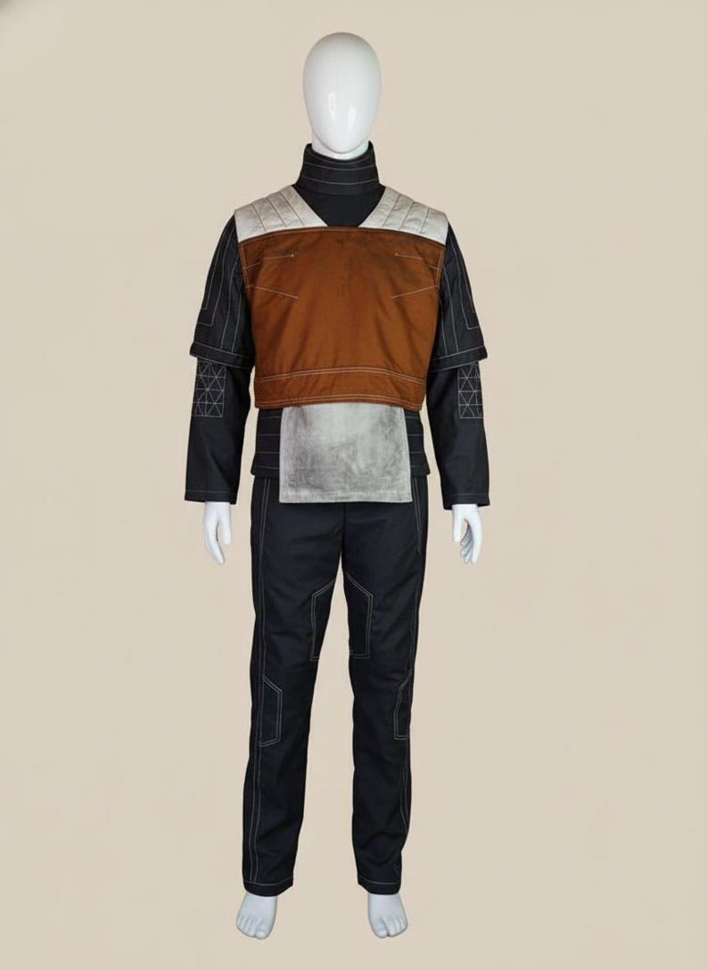 May include: A full costume displayed on a mannequin. The outfit includes a black turtleneck, black trousers, and a brown and grey vest. White stitching accents the black fabric. The vest has a quilted design on the shoulders.