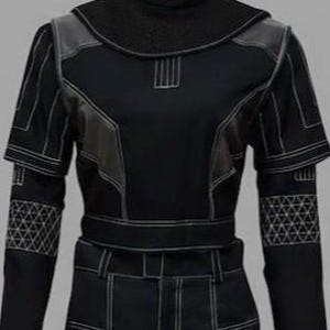 K&ouml;nnte beinhalten: Ein schwarzes Langarmshirt mit hohem Stehkragen, wei&szlig;en Kontrastn&auml;hten, strukturierten Schulterpartien und einem geometrischen Dreiecksgittermuster an den Unterarmen. Das Kleidungsst&uuml;ck ist bauchfrei geschnitten und hat eng anliegende &Auml;rmel.