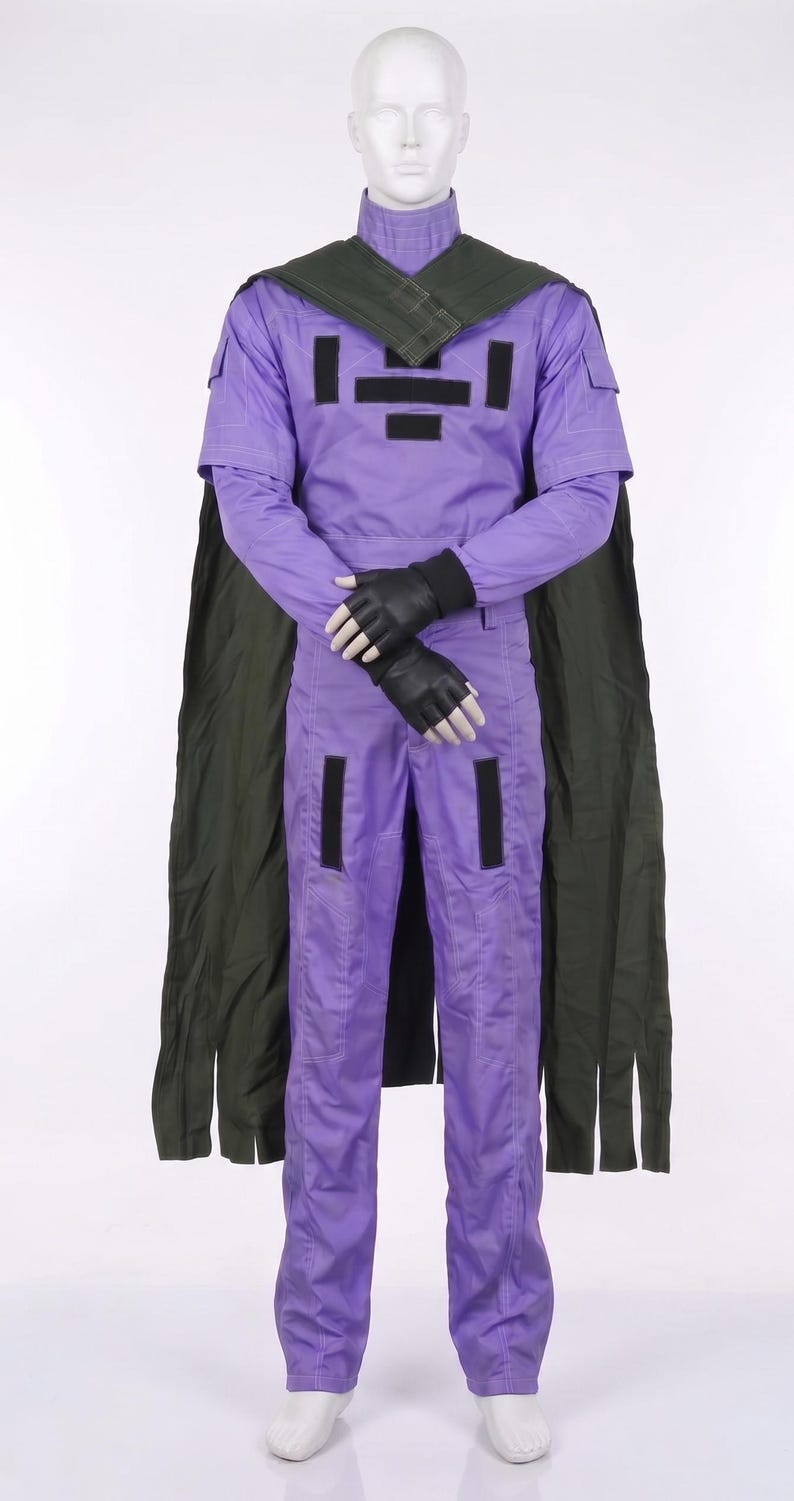 May include: A lavender jumpsuit with a high collar, short sleeves, and long pants. The garment features black rectangular patches on the chest and legs, a dark olive green cape draped over the shoulders, and black fingerless gloves on the hands.