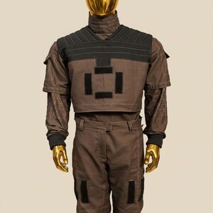 May include: A white ceramic mug with a black handle and the text "But First, Coffee" in a bold, black font. The mug is set against a blurred background, suggesting a cozy setting.