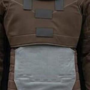May include: A brown tactical vest featuring a dark grey cowl draped over the shoulders, a chest plate with three rectangular dark grey accents, and a large, light grey abdominal armour plate with moulded geometric detailing and horizontal stitching.