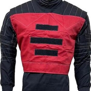 May include: A long-sleeve jacket featuring a black base with a prominent red chest panel. The red section includes three horizontal black rectangular patches. The shoulders and sleeves are detailed with black quilted stitching patterns and a high collar.