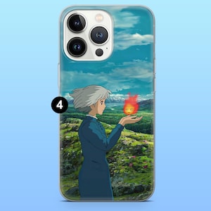 Peut inclure: Coque de t&eacute;l&eacute;phone transparente avec une sc&egrave;ne d'anime. Un personnage aux cheveux blancs et en tenue bleue tient une petite cr&eacute;ature enflamm&eacute;e. Le fond montre un paysage verdoyant sous un ciel bleu nuageux.