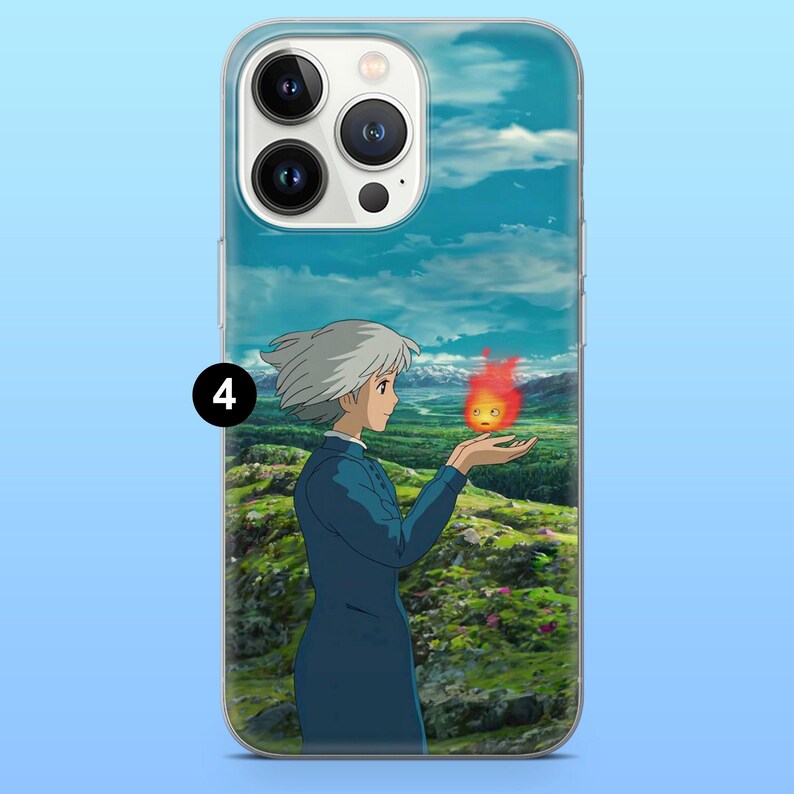 Peut inclure: Coque de t&eacute;l&eacute;phone transparente avec une sc&egrave;ne d'anime. Un personnage aux cheveux blancs et en tenue bleue tient une petite cr&eacute;ature enflamm&eacute;e. Le fond montre un paysage verdoyant sous un ciel bleu nuageux.