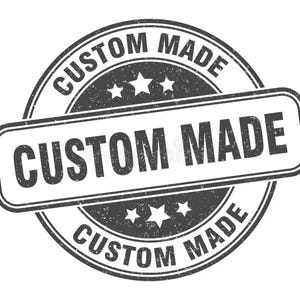 May include: A distressed, circular stamp with the words "CUSTOM MADE" in a bold, sans-serif font. The text is arranged in a circular pattern and also in a rectangular shape. The stamp features three stars and a grunge texture.