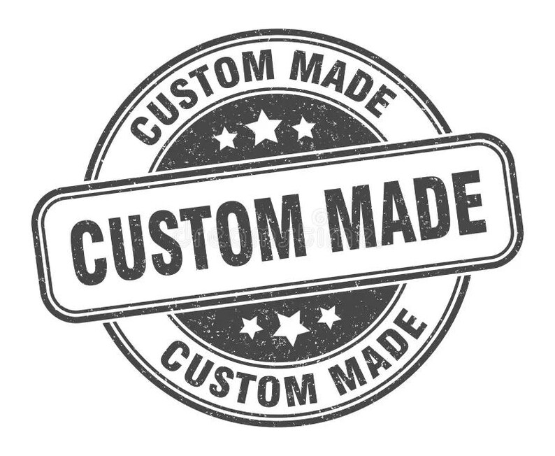May include: A distressed, circular stamp with the words "CUSTOM MADE" in a bold, sans-serif font. The text is arranged in a circular pattern and also in a rectangular shape. The stamp features three stars and a grunge texture.