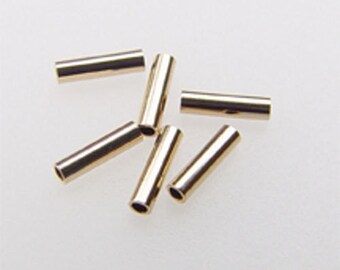 May include: Six gold-colored metal tube crimp beads. The beads are cylindrical and have a smooth, shiny finish.
