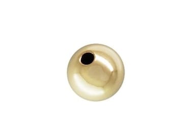 May include: A single gold bead with a hole in the center.