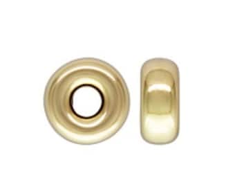 May include: Two gold-colored metal beads, one with a hole in the center and the other solid.