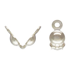 May include: Two silver-colored bead tips, one open and one closed. The open bead tip is V-shaped, with two rounded cups and a narrow connecting base. The closed bead tip is a rounded shape with a loop at the top.