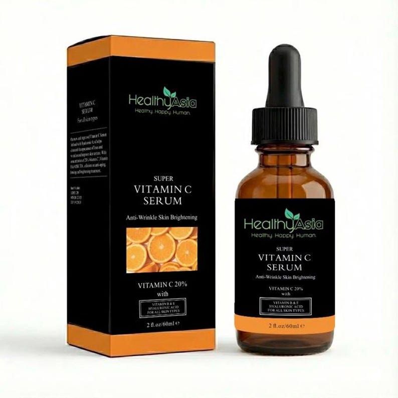Puede incluir: Una botella de vidrio marr&oacute;n y una caja negra de Healthy Asia Super Vitamin C Serum. La botella tiene un cuentagotas negro y una etiqueta negra con texto blanco. La caja tiene detalles en naranja y una foto de rodajas de naranja.